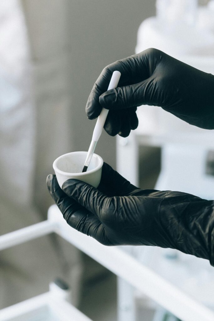 Close-up of hands applying permanent makeup with precision brush.